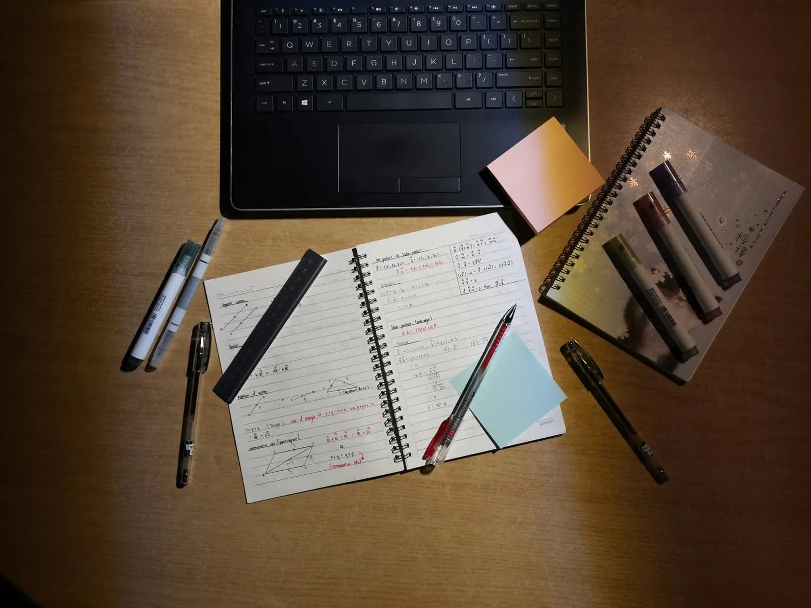 Laptop, notebook and pens on a desk for planning a menu