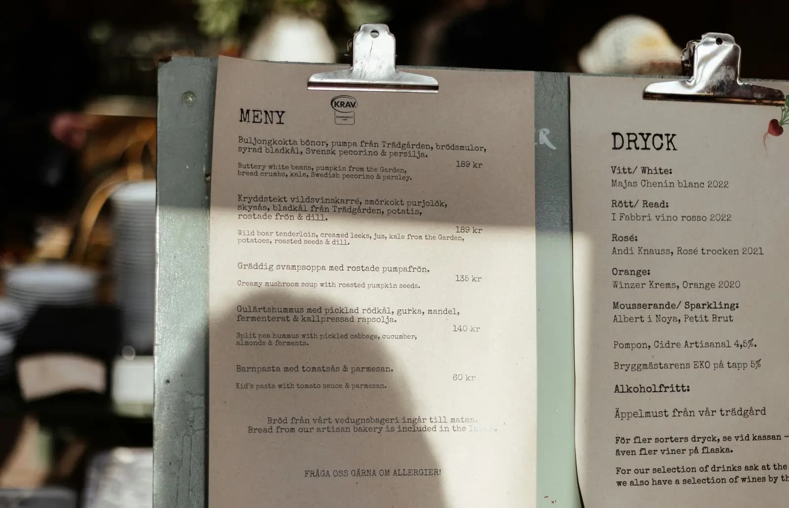 Printed menu on a clipboard beside a cup of coffee