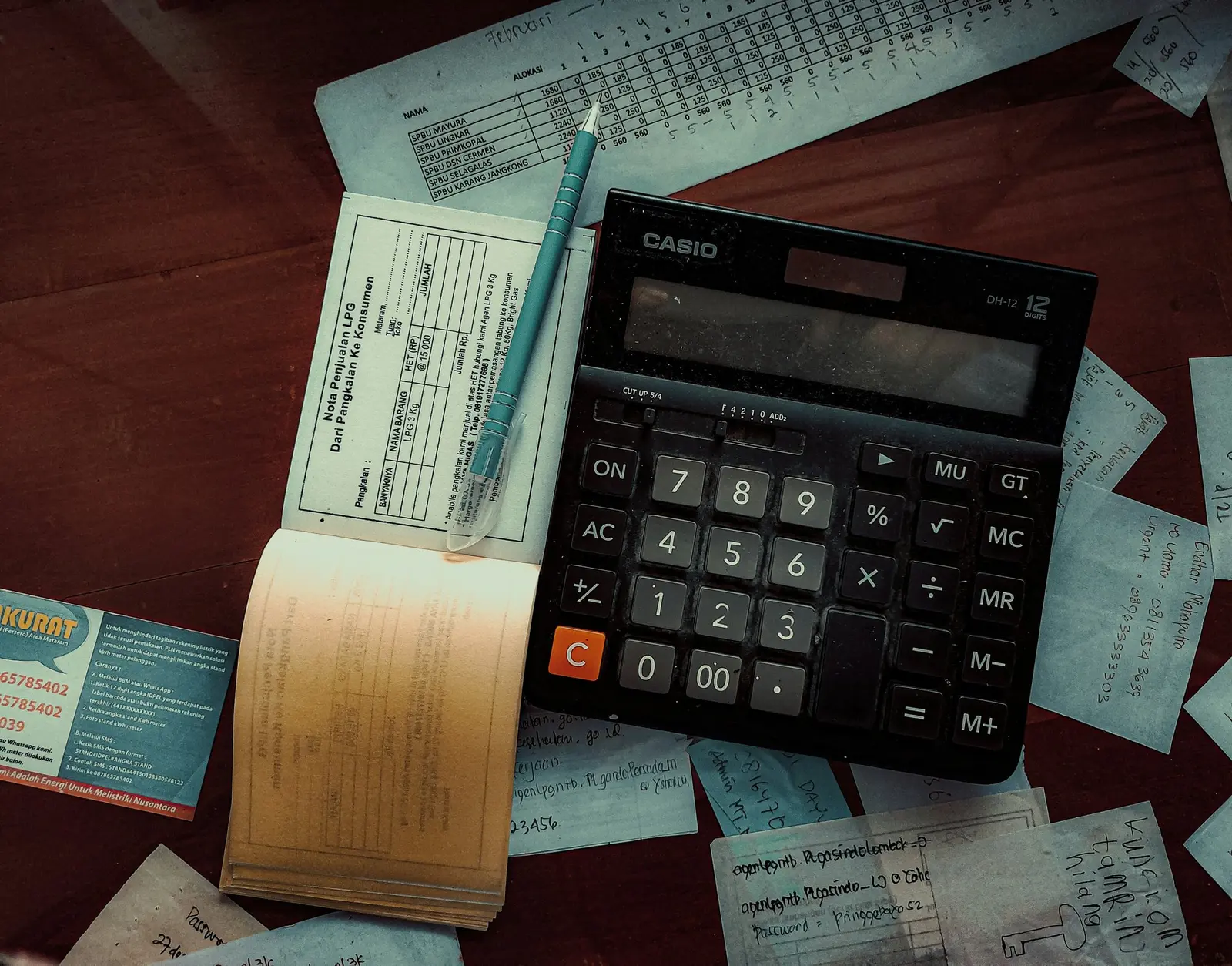 Calculator on a table with invoices and a receipt book