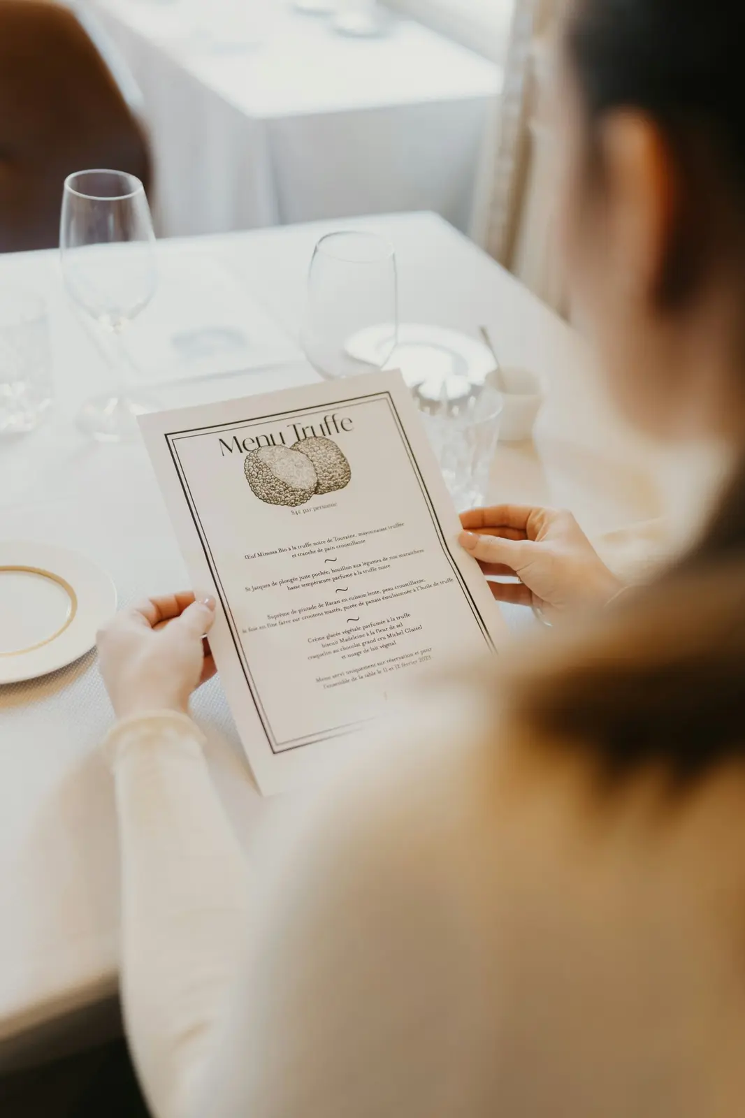 Guest reading a menu at a restaurant table